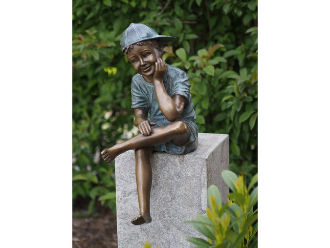 Bronzen beeld Zittende jongen met pet 59x24x36cm
